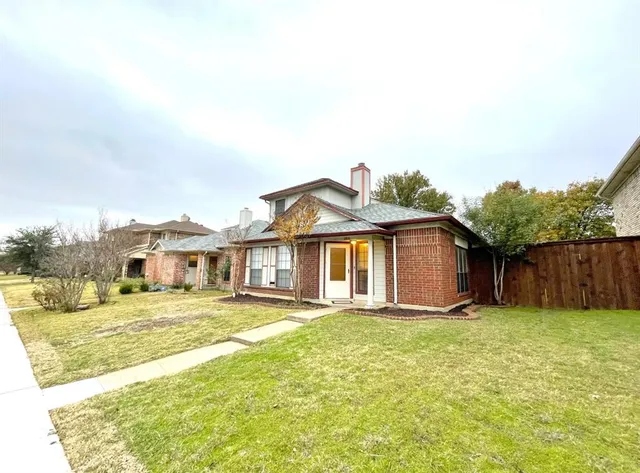 a view of a house with a big yard and large trees