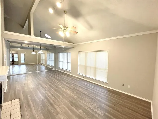 a view of an empty room with wooden floor