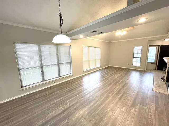 a view of wooden floor and windows in a room