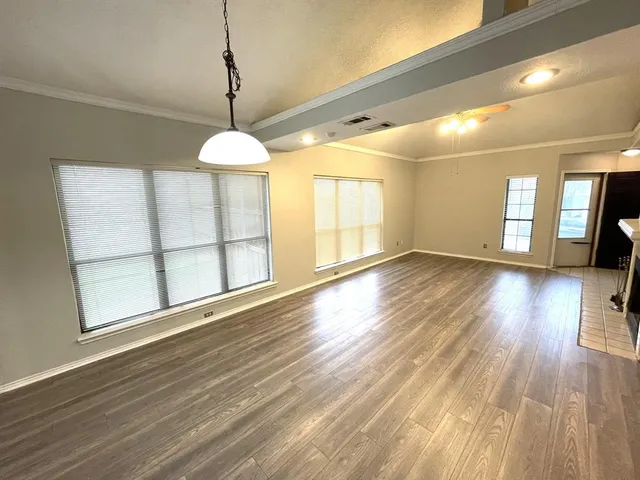 a view of a room with wooden floor windows and a chandelier