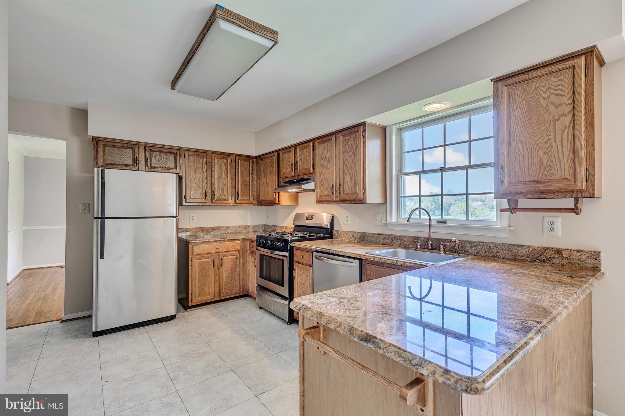 10801 Golf Course Court Bowie, MD 20721 - Photo 11 of 52 a kitchen with granite countertop a sink stove and refrigerator