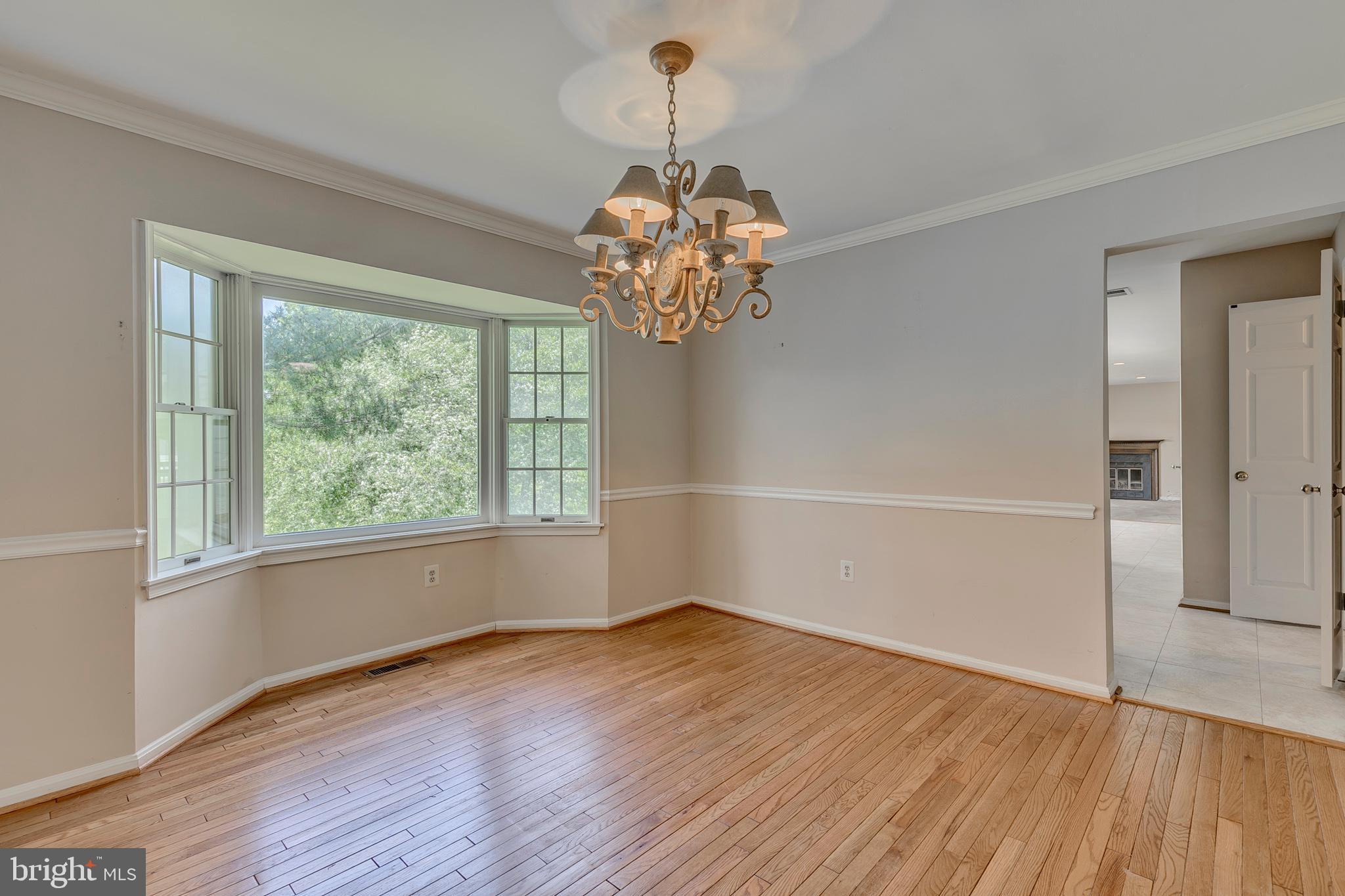 10801 Golf Course Court Bowie, MD 20721 - Photo 9 of 52 a view of a room with wooden floor and chandelier