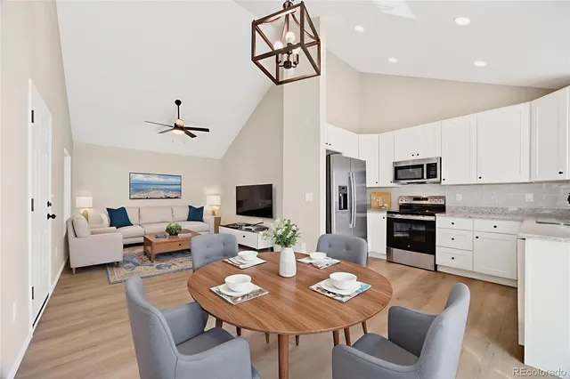 a living room with furniture a flat screen tv and kitchen view