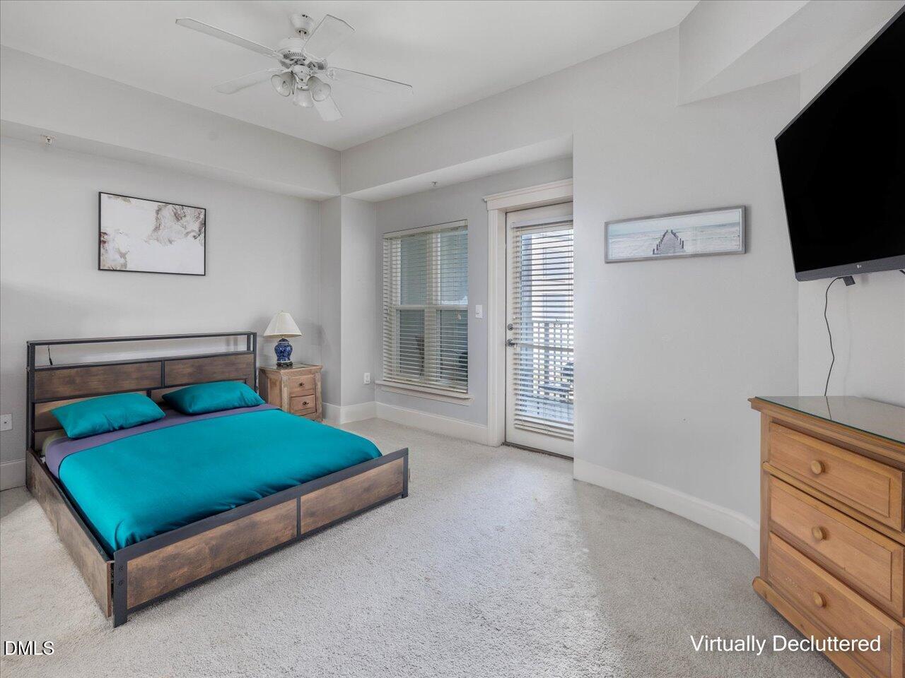 222 Glenwood Avenue, Unit 304 Raleigh, NC 27603 - Photo 15 of 23 a bedroom with a bed and a flat screen tv