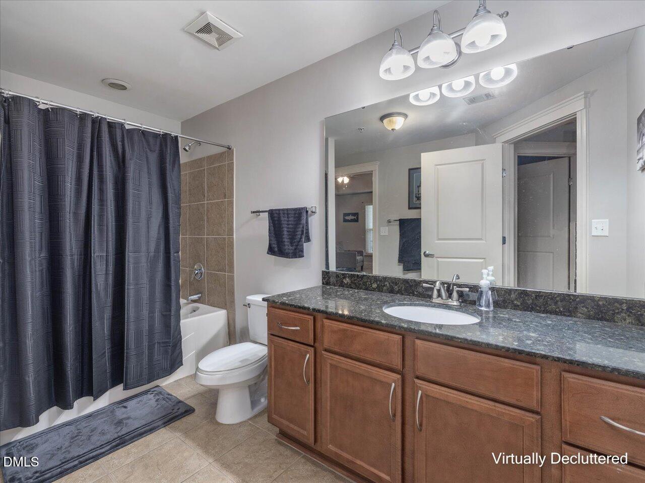 222 Glenwood Avenue, Unit 304 Raleigh, NC 27603 - Photo 18 of 23 a spacious bathroom with a granite countertop sink a toilet and a large mirror
