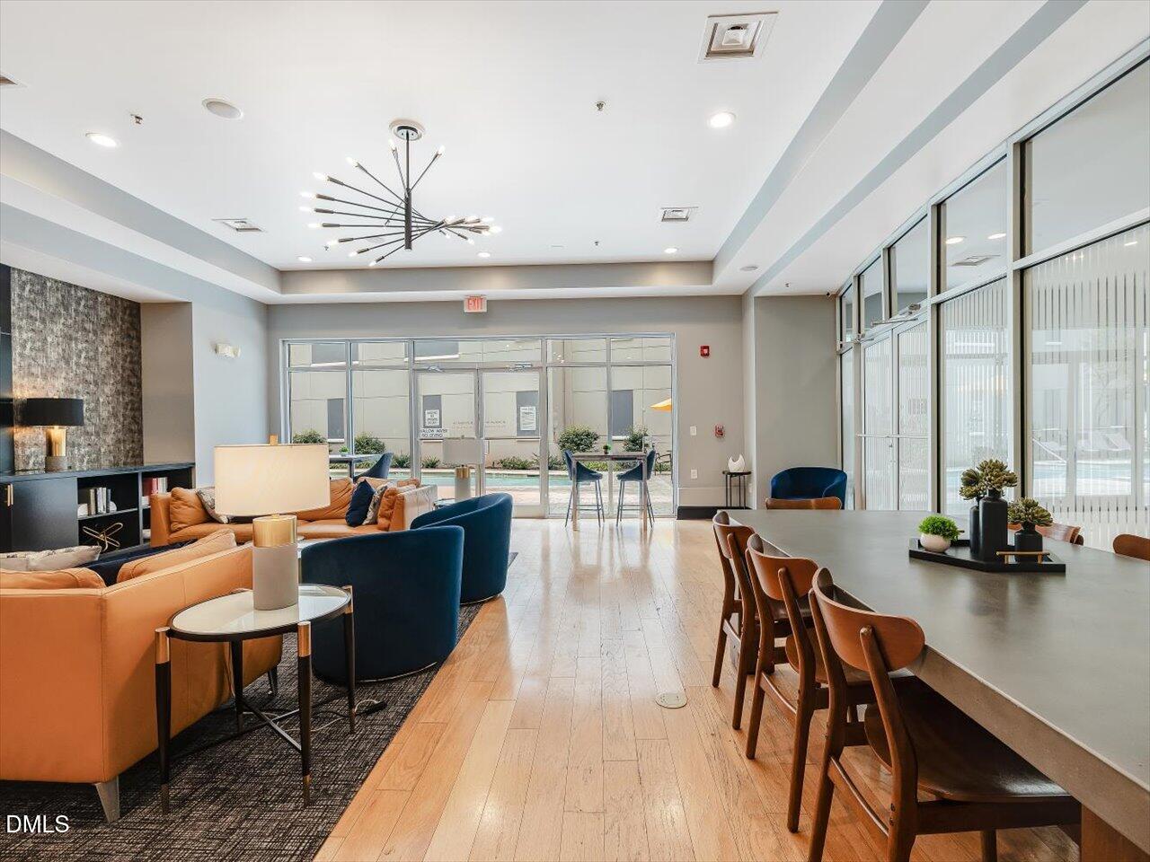 222 Glenwood Avenue, Unit 304 Raleigh, NC 27603 - Photo 6 of 23 a living room with furniture kitchen view and a wooden floor