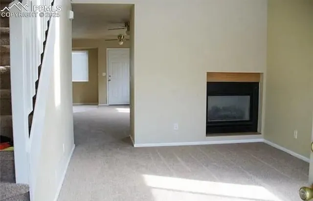 a view of a hallway with wooden floor and a cabinet