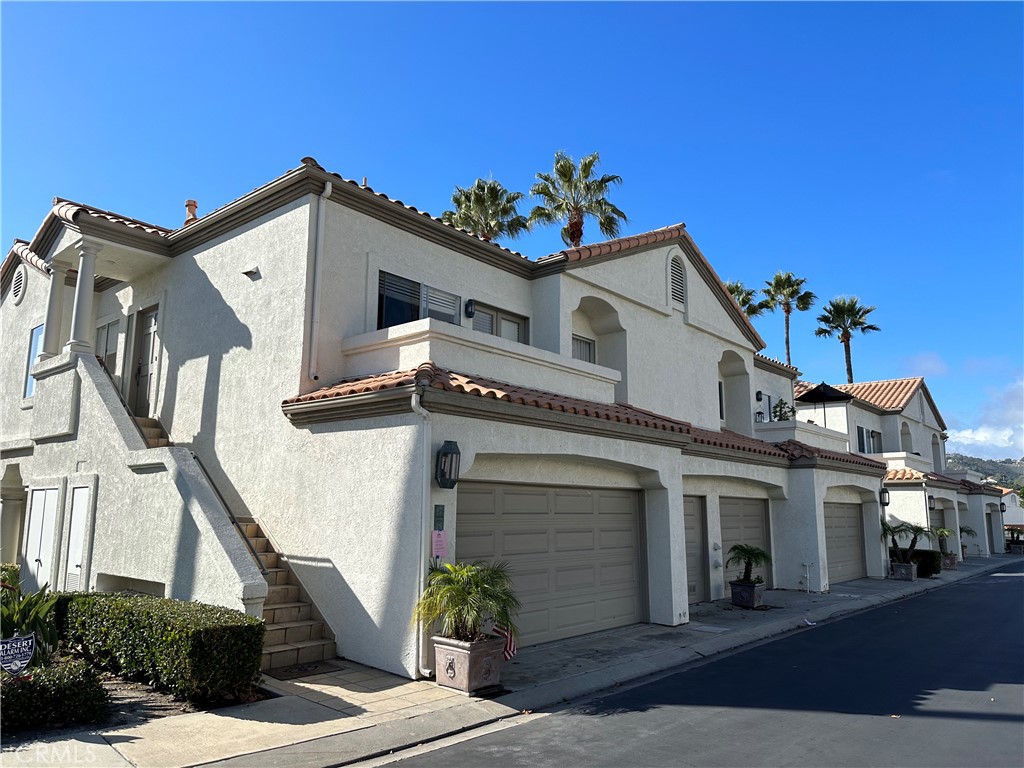 17 Centre Court, Unit 86 Dana Point, CA 92629 - Photo 4 of 21 a view of a white house with a small yard and potted plants