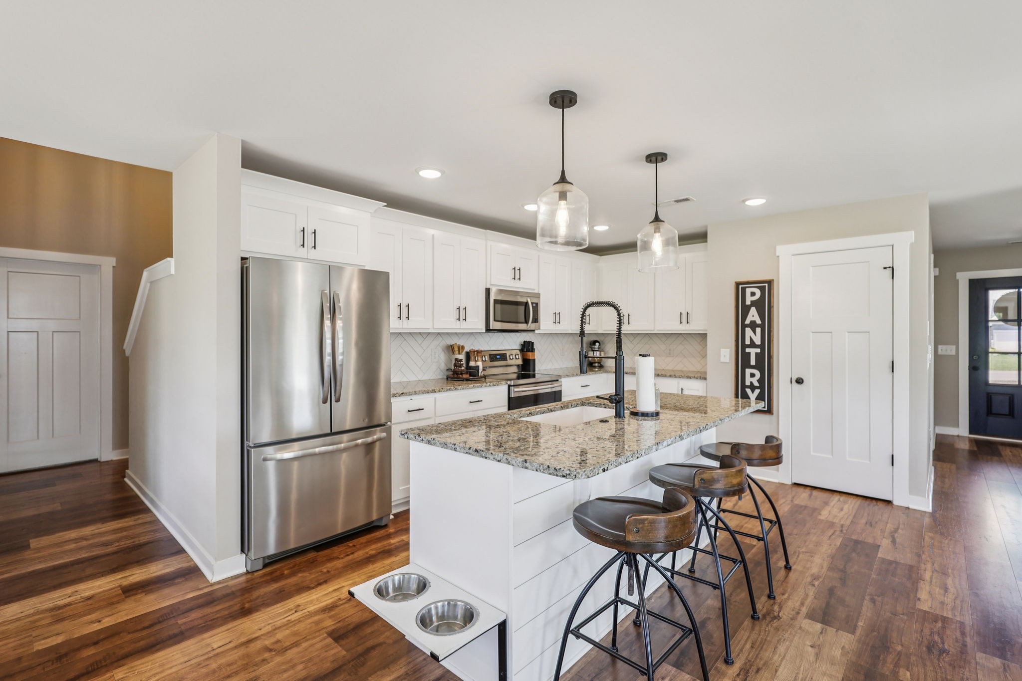 310 Skipping Stone Road Christiana, TN 37037 - Photo 8 of 50 a kitchen with stainless steel appliances granite countertop a refrigerator a sink dishwasher a stove and white cabinets with wooden floor