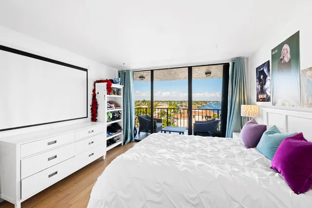 a bedroom with a bed a table and painting on the wall