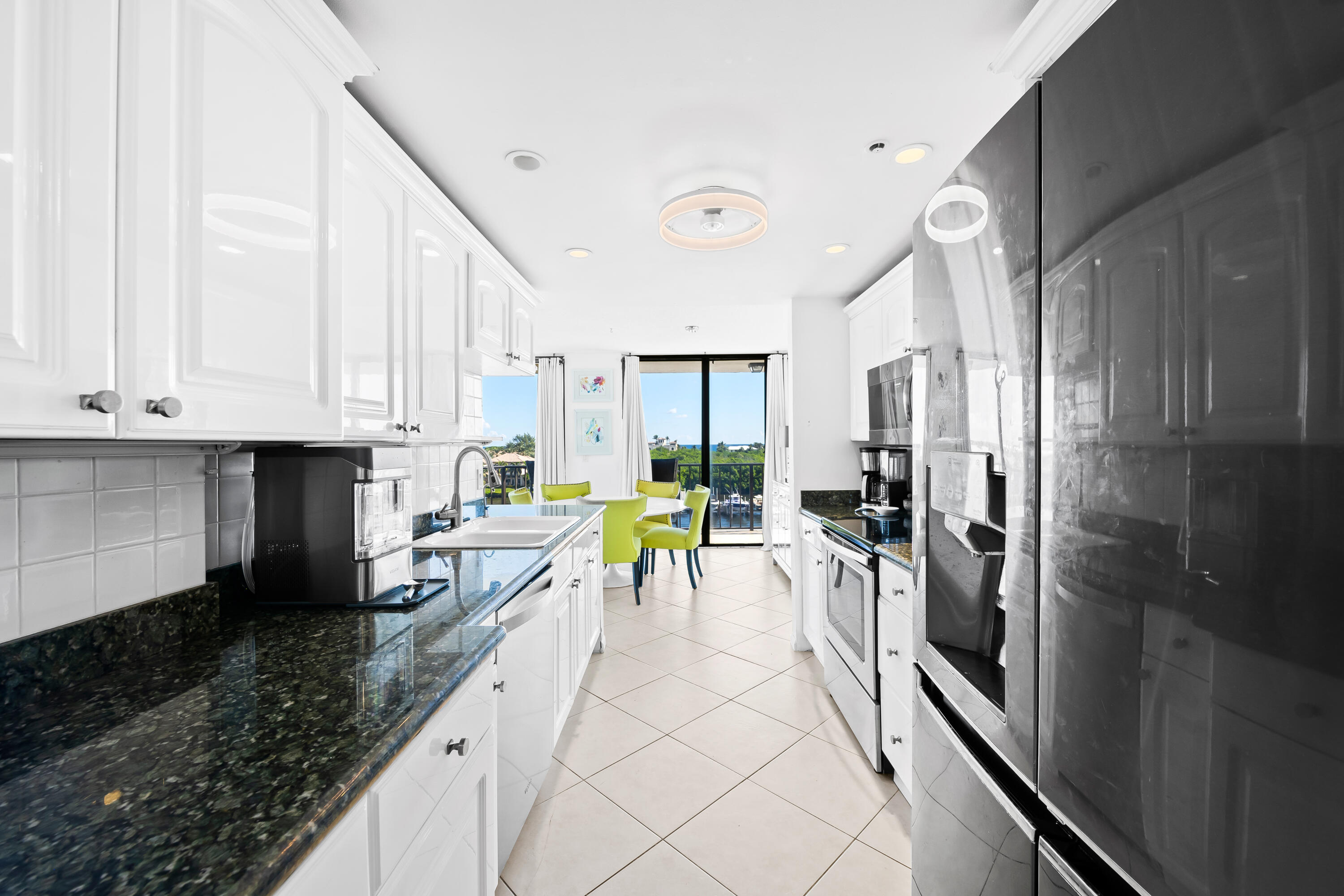 899 Jeffery Street, Unit 614 Boca Raton, FL 33487 - Photo 9 of 60 a kitchen with stainless steel appliances kitchen island granite countertop a refrigerator a stove and a sink with cabinets