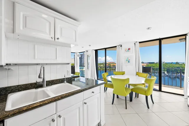 a large white kitchen with a large window and swimming pool