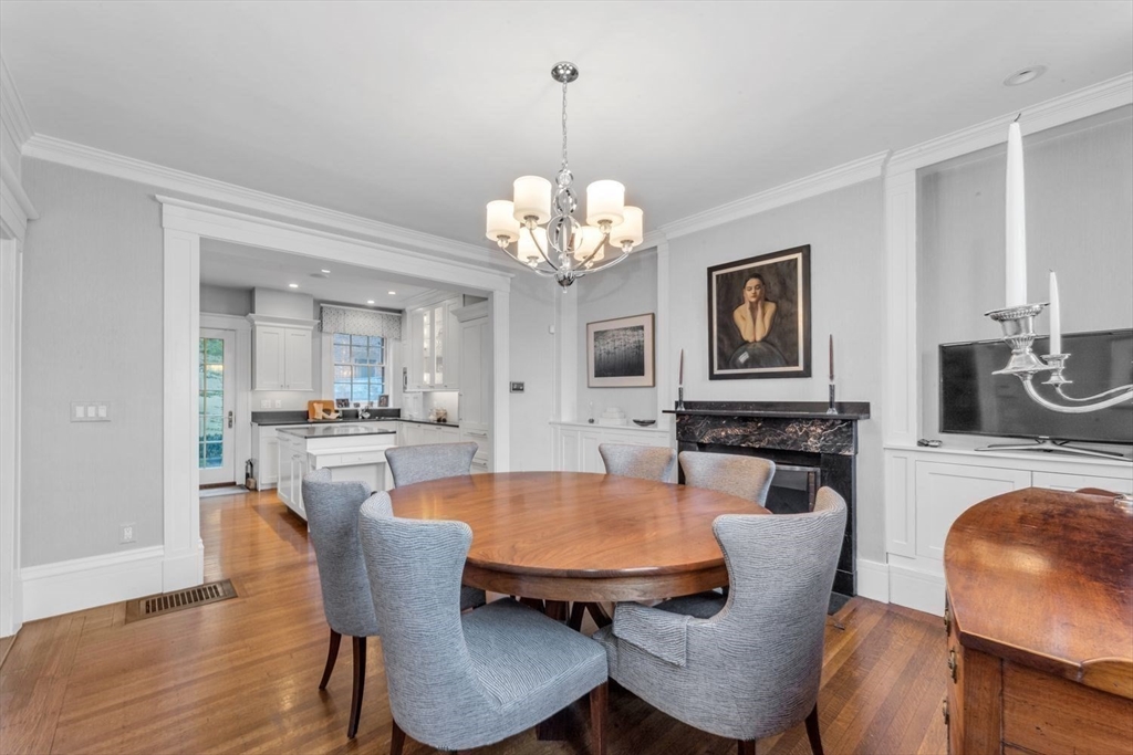52 River Street Boston, MA 02108 - Photo 12 of 37 a dining room with wooden floor a chandelier a wooden table and chairs