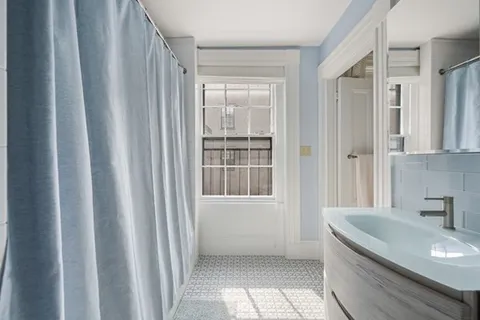 a bathroom with a granite countertop sink and a large mirror