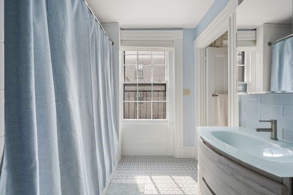 a bathroom with a granite countertop sink and a large mirror