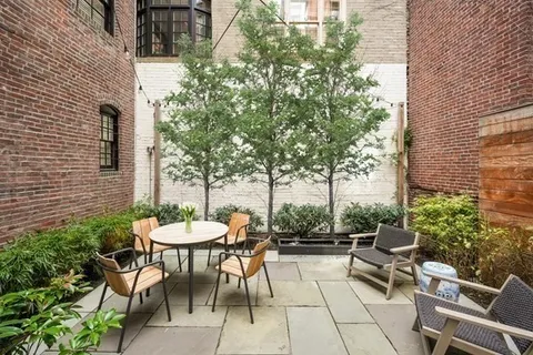 a view of a patio with a table and chairs and a barbeque