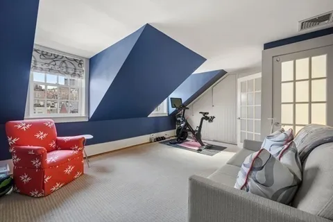 a living room with furniture gym equipment and a large window