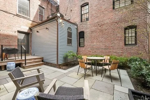a backyard of a house with table and chairs