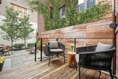 a view of a roof deck with table and chairs and wooden floor