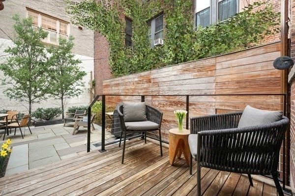 a view of a roof deck with table and chairs and wooden floor