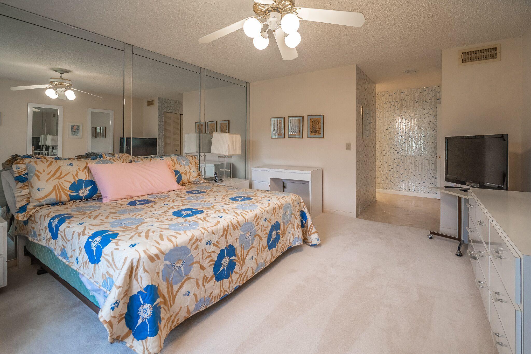 9276 Vista Del Lago, Unit E Boca Raton, FL 33428 - Photo 11 of 23 a bedroom with a bed and a flat tv screen on dresser