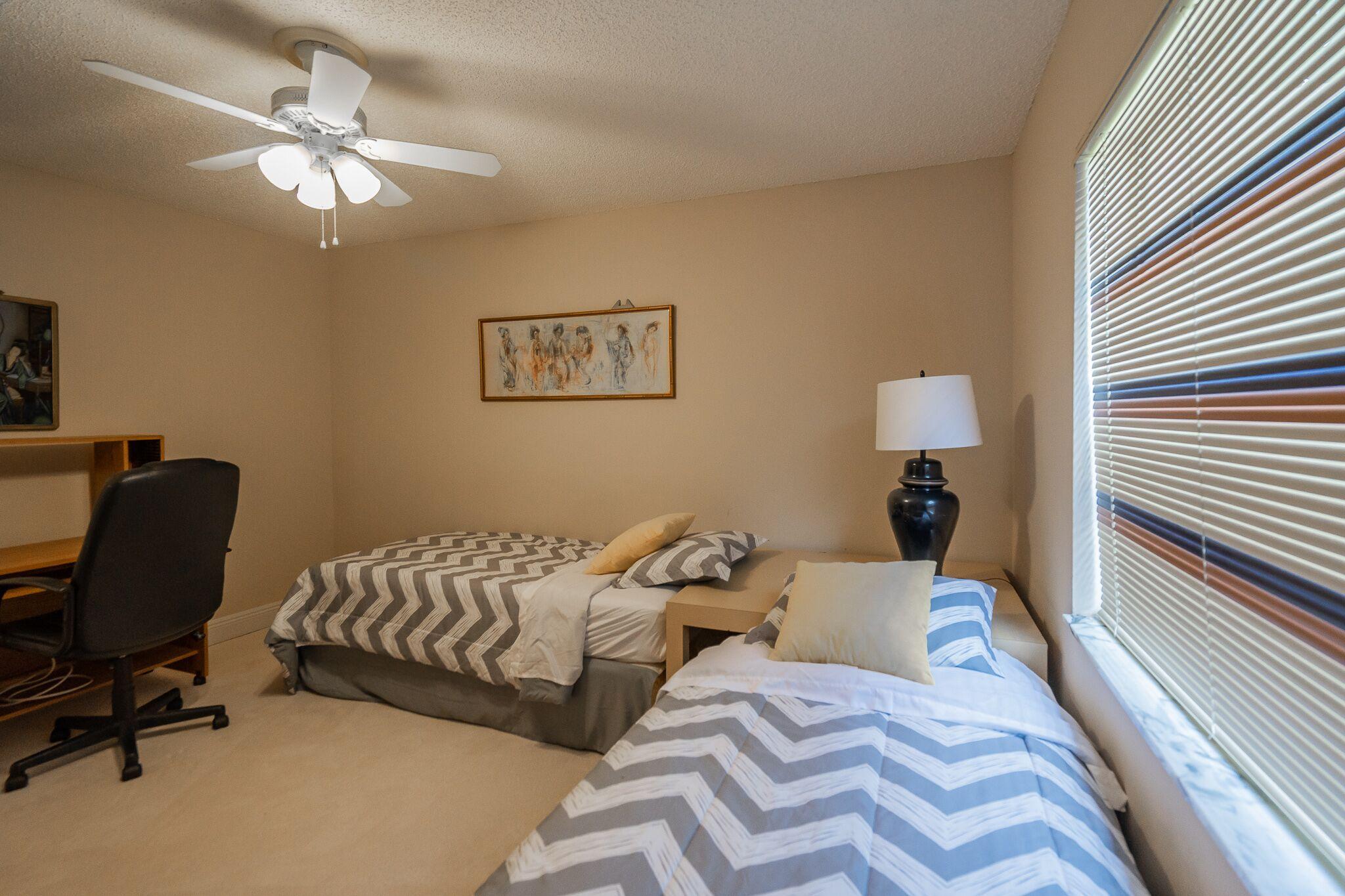 9276 Vista Del Lago, Unit E Boca Raton, FL 33428 - Photo 17 of 23 a bedroom with a bed and a chandelier