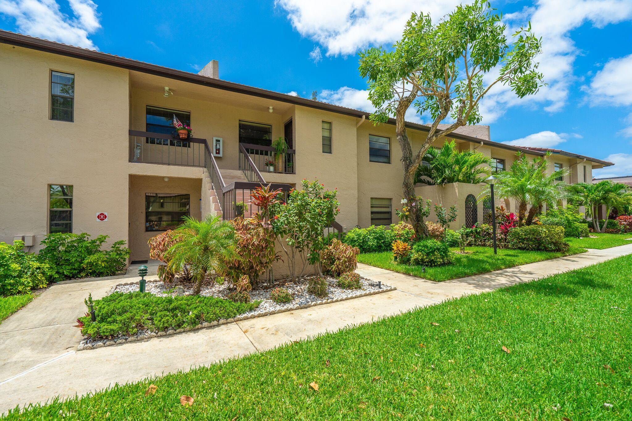 9276 Vista Del Lago, Unit E Boca Raton, FL 33428 - Photo 21 of 23 a front view of a house with a yard