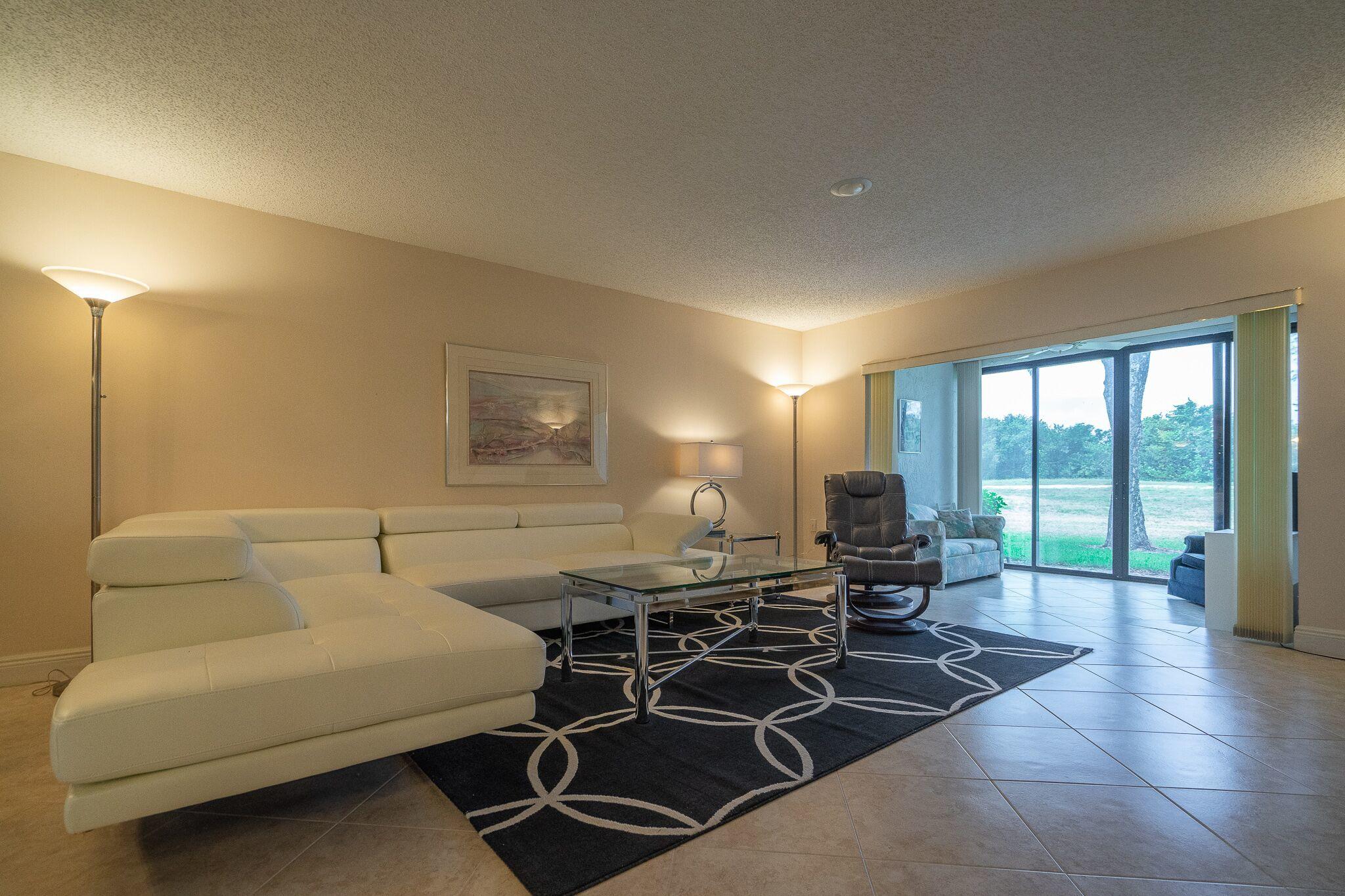 9276 Vista Del Lago, Unit E Boca Raton, FL 33428 - Photo 4 of 23 a living room with furniture a rug and a large window