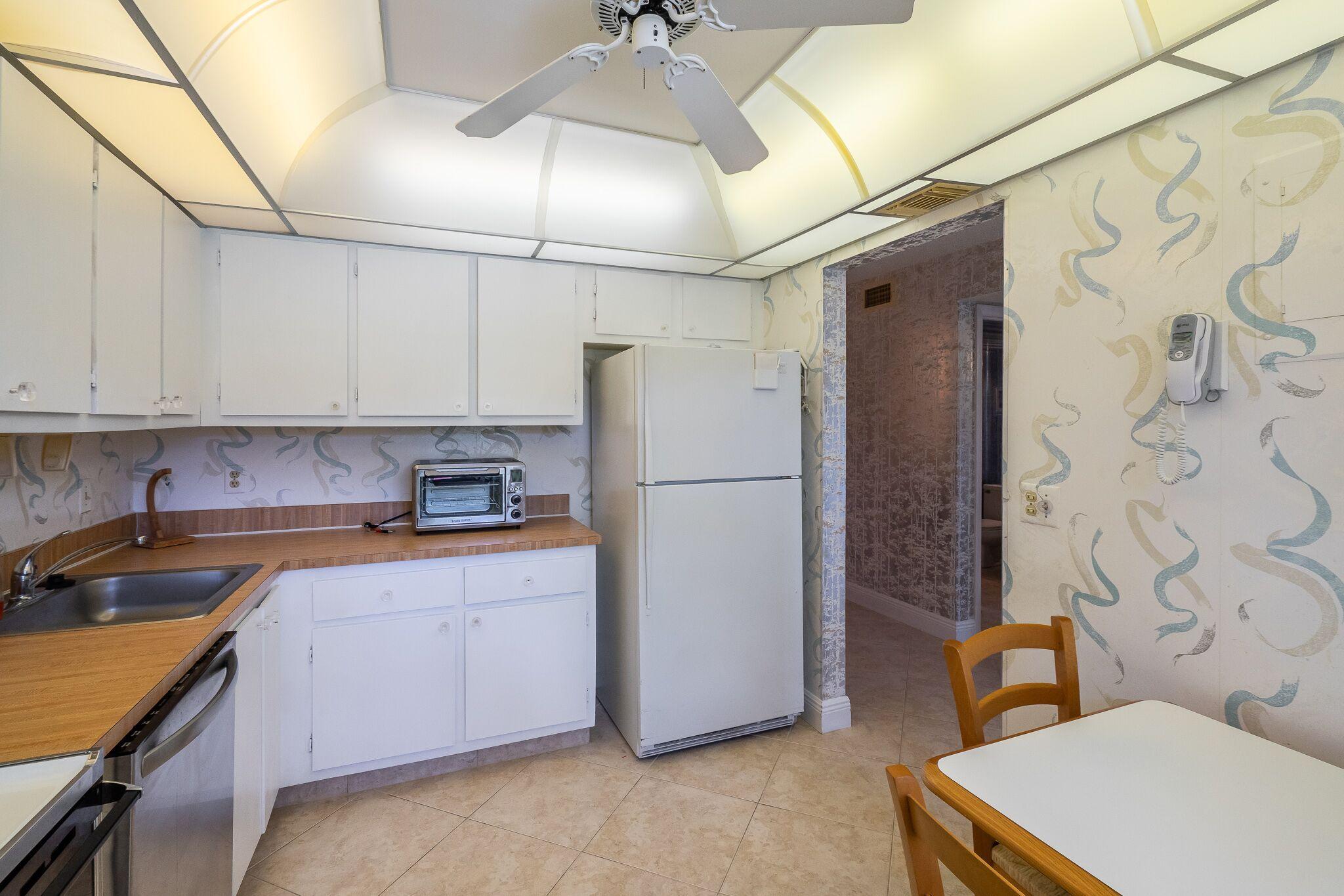 9276 Vista Del Lago, Unit E Boca Raton, FL 33428 - Photo 7 of 23 a kitchen with stainless steel appliances granite countertop a refrigerator a sink and white cabinets
