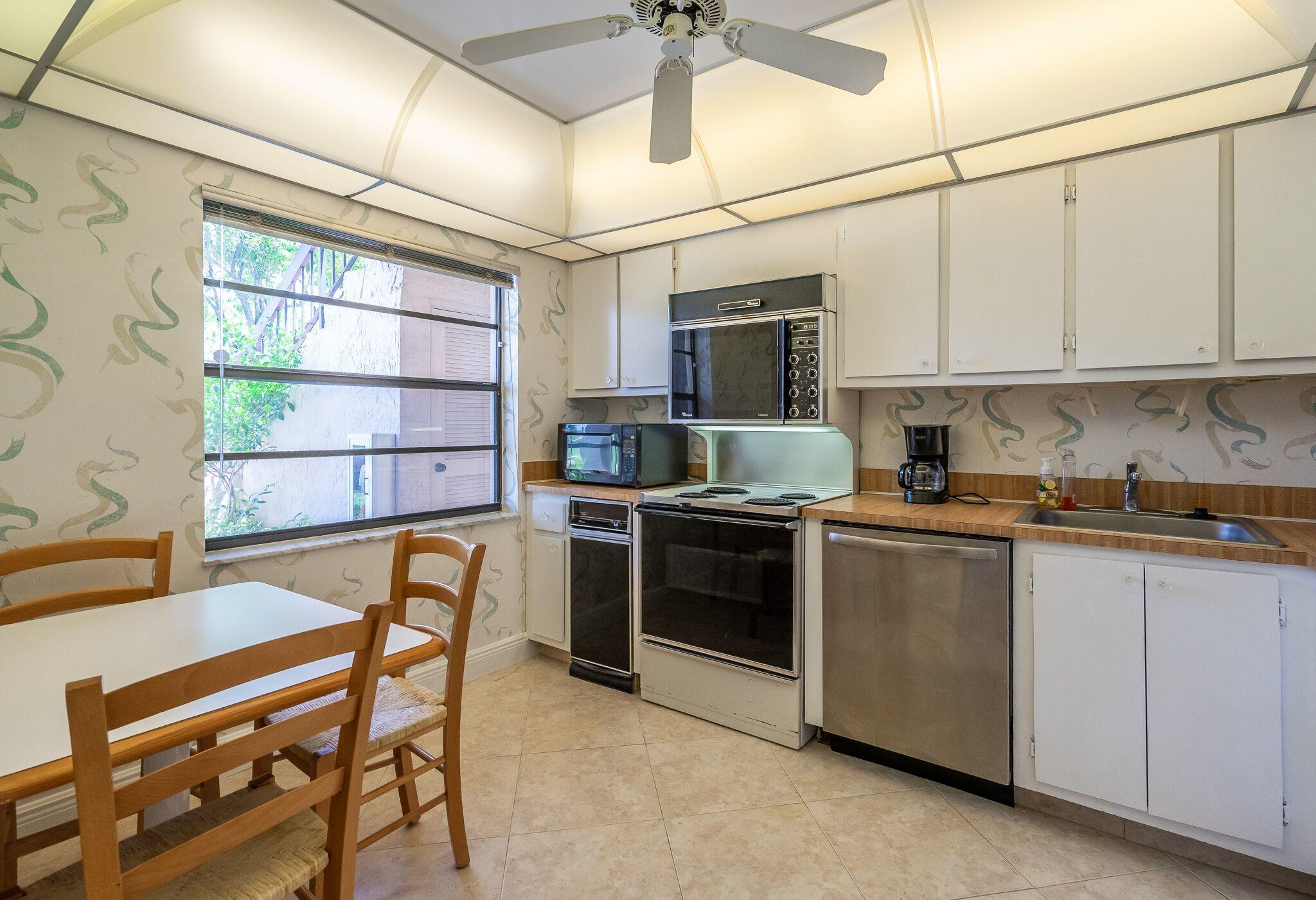9276 Vista Del Lago, Unit E Boca Raton, FL 33428 - Photo 9 of 23 a kitchen with stainless steel appliances granite countertop a stove a sink dishwasher a microwave oven with granite countertops and cabinets