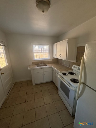 805 West Kern Road, Unit 807 Killeen, TX 76541 - Photo 3 of 4 a kitchen with a stove a sink and a refrigerator