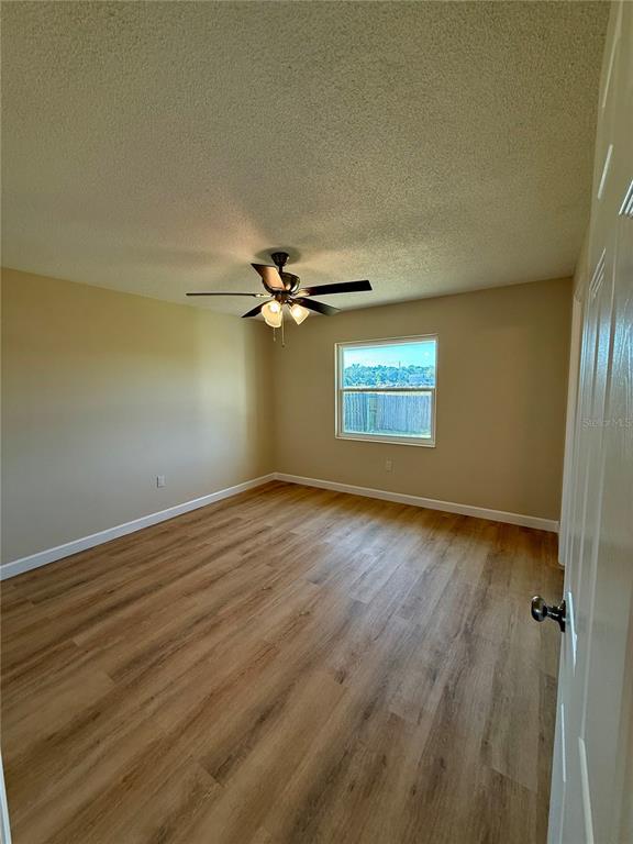 3541 65th Ave Circle East Sarasota, FL 34243 - Photo 13 of 17 an empty room with wooden floor closet and windows
