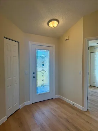 a view of an empty room with closet and wooden floor