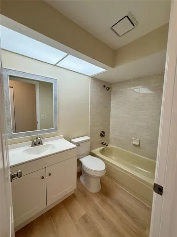 a bathroom with a double vanity sink toilet mirror and bathtub