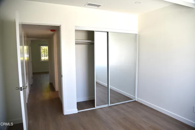 an empty room with wooden floor & closet