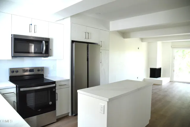 a kitchen with stainless steel appliances a stove microwave and refrigerator