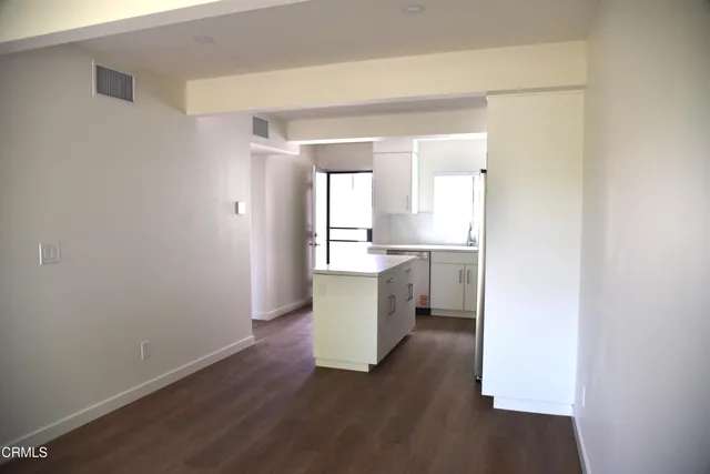 a kitchen with a refrigerator and white cabinets
