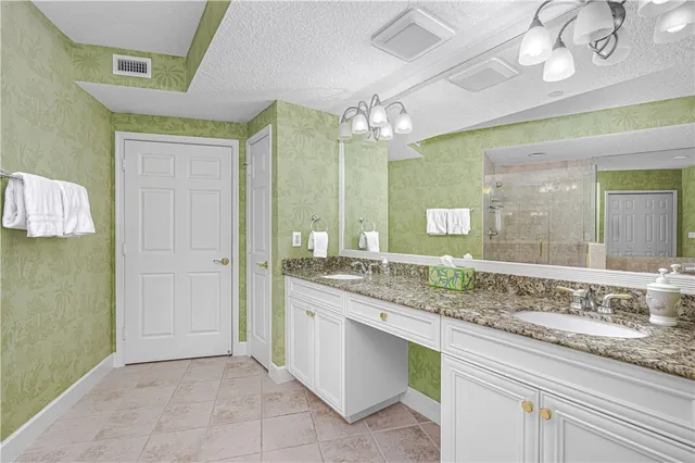 a spacious bathroom with a granite countertop tub shower and mirror