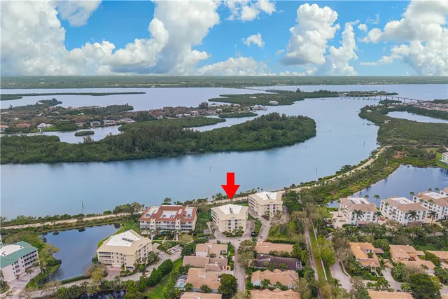 an aerial view of a house with a garden and lake view