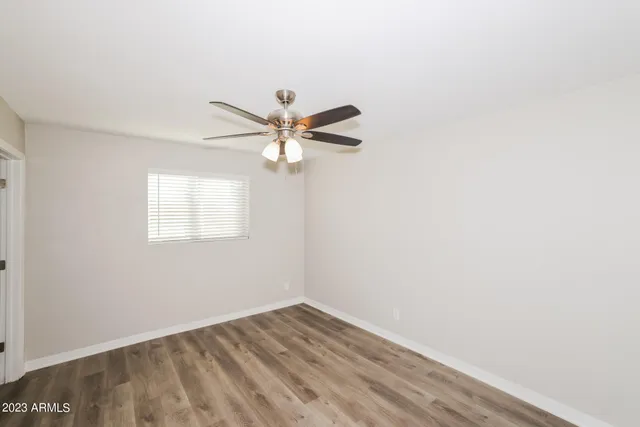 a view of a room with wooden floor and small window
