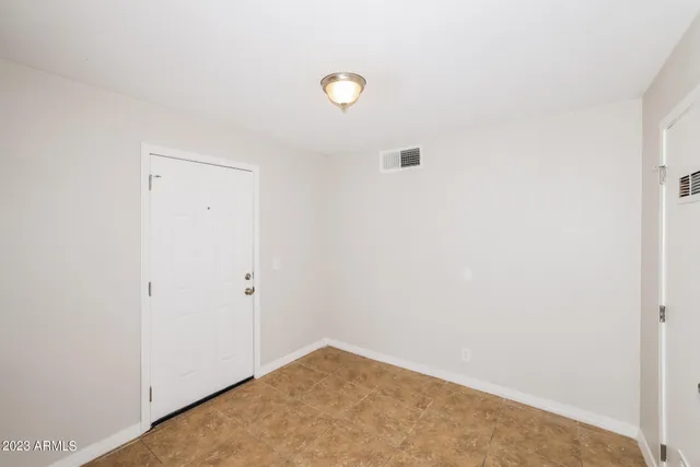 an empty room with closet and a ceiling fan