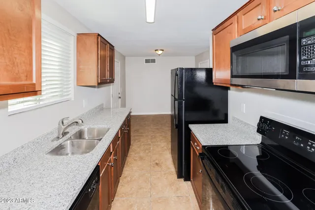 a kitchen with granite countertop a sink and a stove top oven with wooden floor