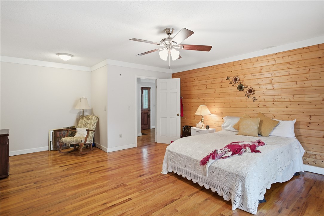 2001 Highway 59 Westminster, SC 29693 - Photo 15 of 38 This spacious bedroom offers ample comfort and natural light, featuring hardwood flooring and wood paneling.