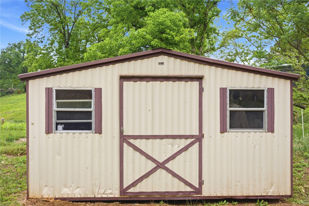 2001 Highway 59 Westminster, SC 29693 - Photo 7 of 38 A quaint storage shed with simple windows, a functional door, and a classic gable roof.