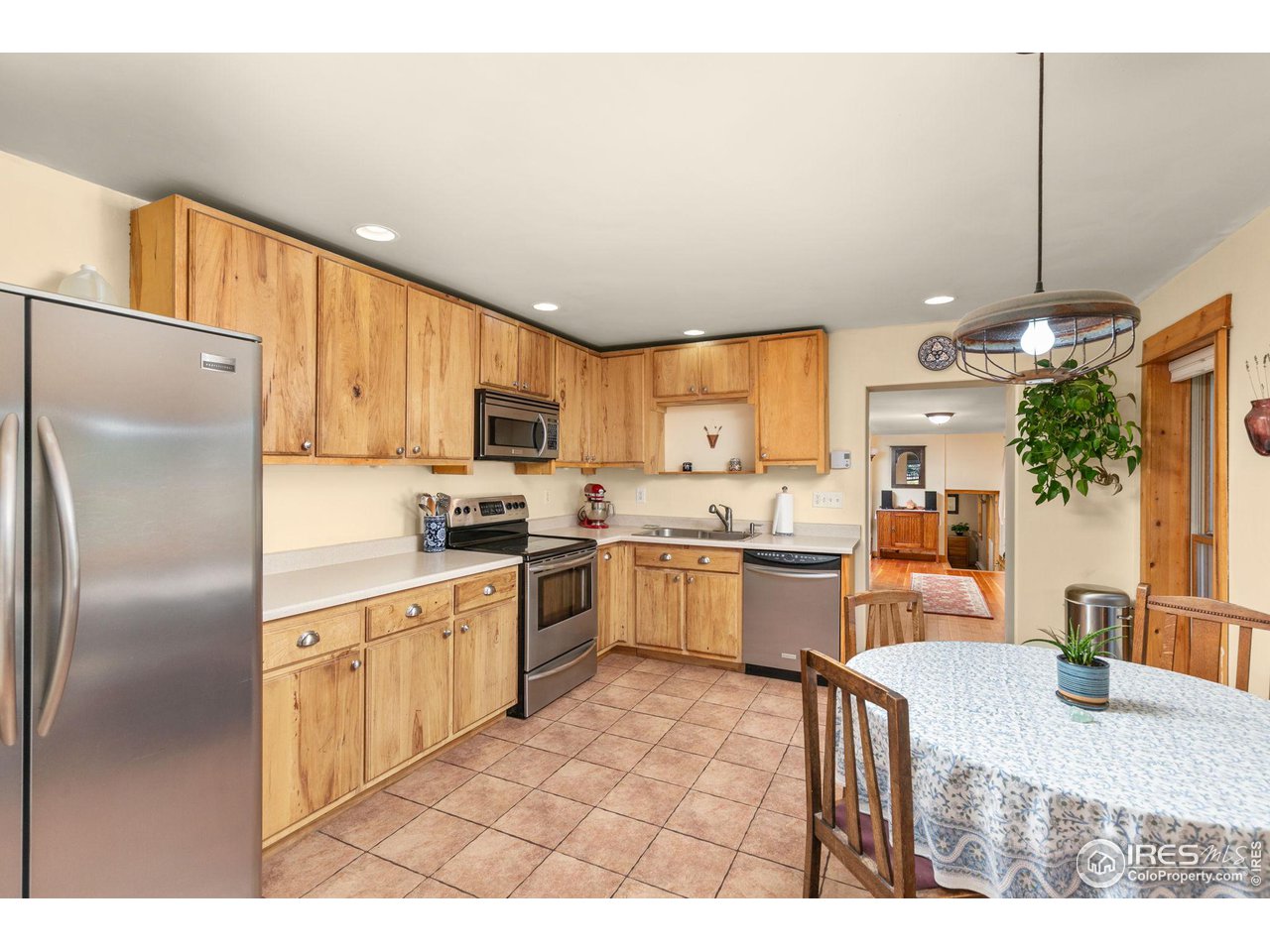 3072 Highway 72 Black Hawk, CO 80422 - Photo 5 of 36 a kitchen with a refrigerator a sink dishwasher with a dining table and chairs