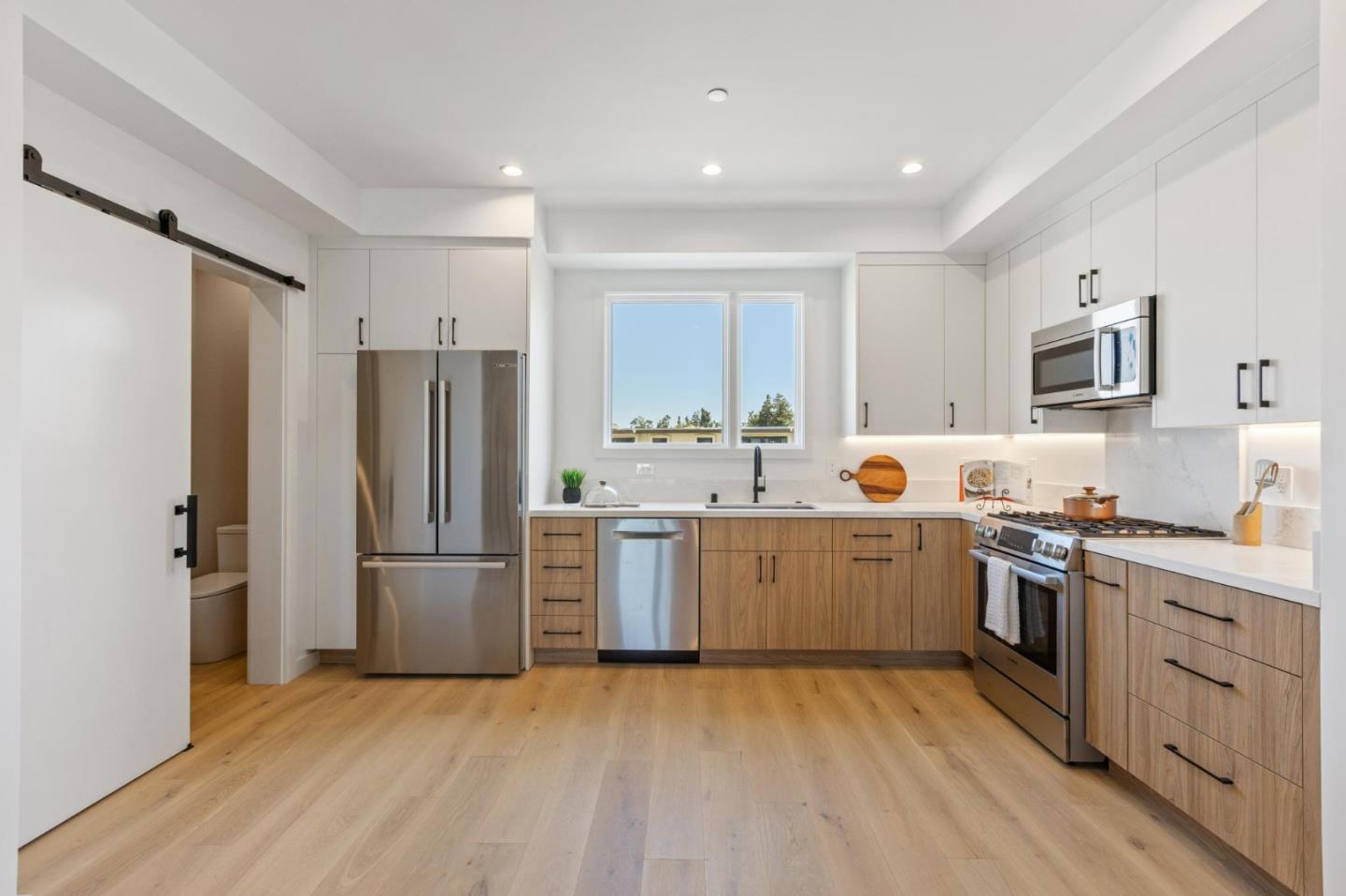 1433 Floribunda Avenue, Unit 5 Burlingame, CA 94010 - Photo 29 of 58 a kitchen with white cabinets and stainless steel appliances