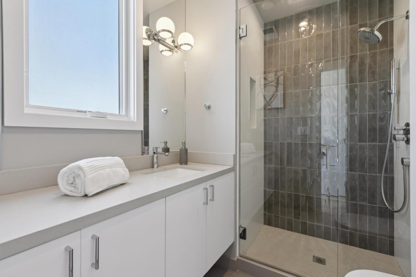 1433 Floribunda Avenue, Unit 5 Burlingame, CA 94010 - Photo 37 of 58 a bathroom with a shower sink and mirror