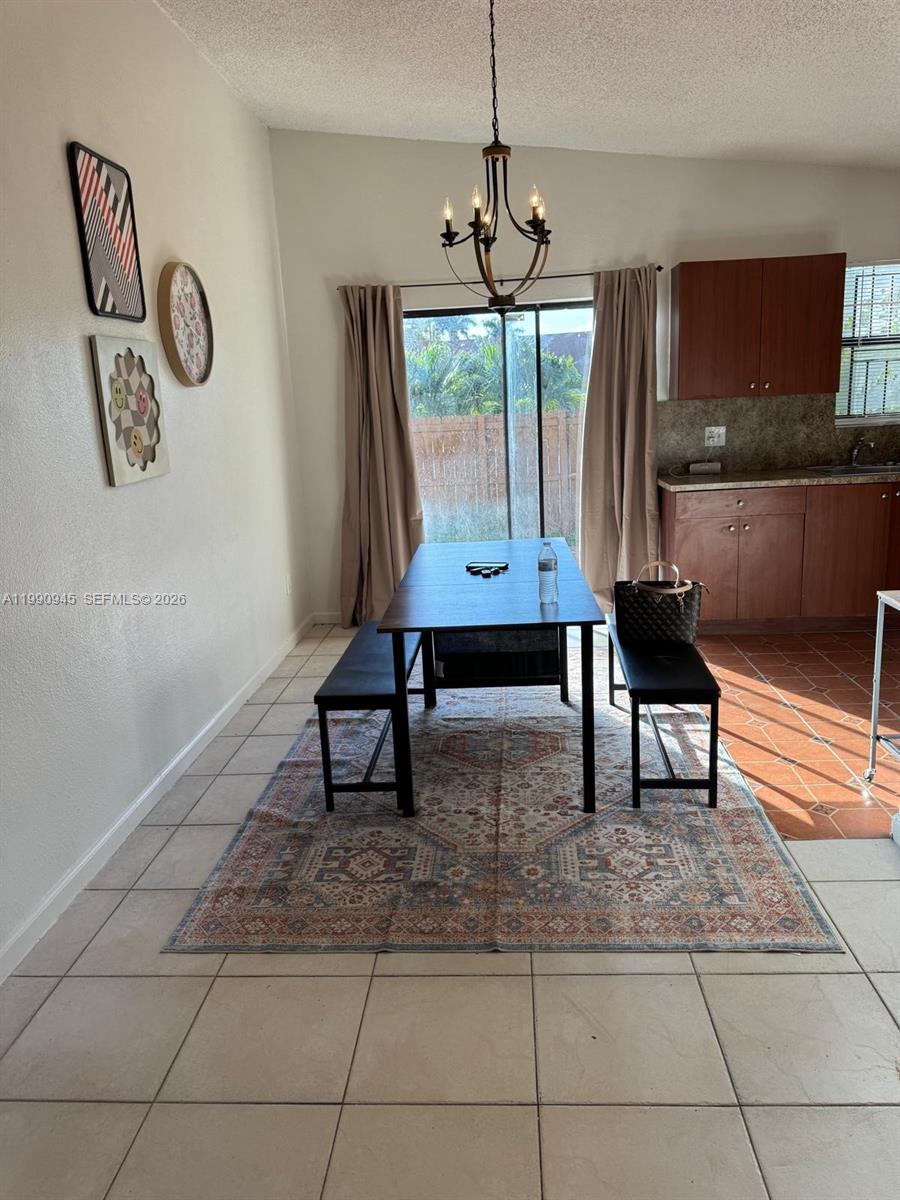 28002 Southwest 140th Court Homestead, FL 33033 - Photo 5 of 12 a living room with a couch and a chandelier