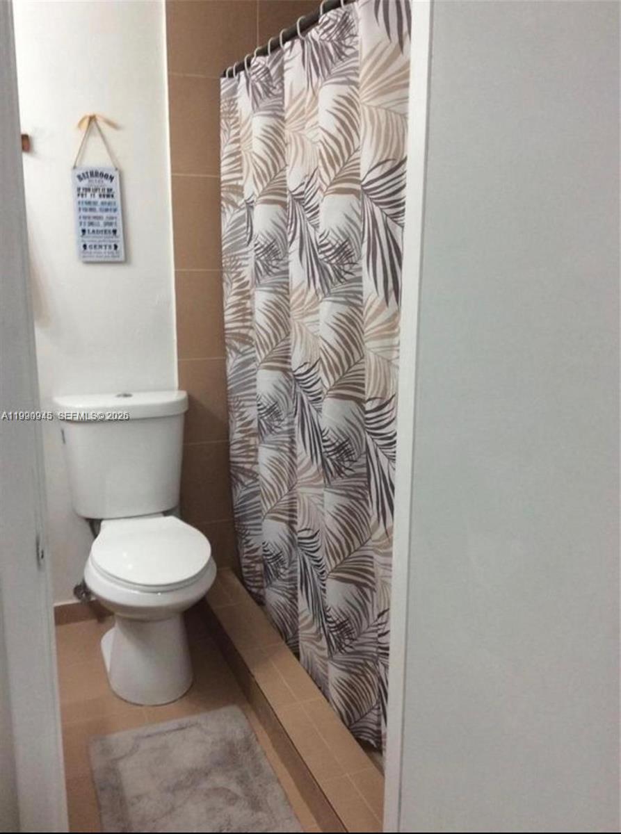28002 Southwest 140th Court Homestead, FL 33033 - Photo 7 of 12 a white toilet sitting next to a shower curtain