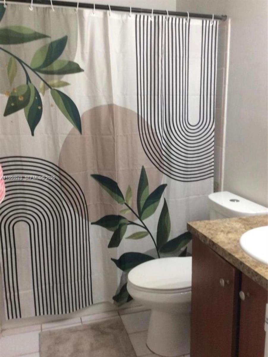 28002 Southwest 140th Court Homestead, FL 33033 - Photo 8 of 12 a bathroom with a granite countertop toilet and a sink